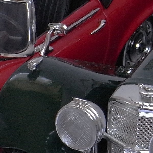 Close-up of a red and black vintage car's front section
