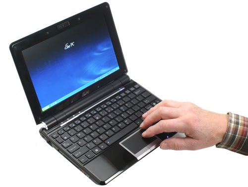 Hand operating an Asus Eee PC 1000HE netbook.