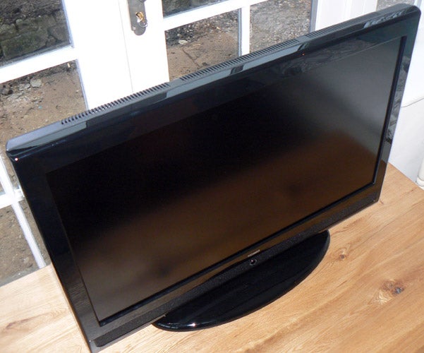 Tesco Technika LCD32-209 32-inch LCD TV on wooden stand.