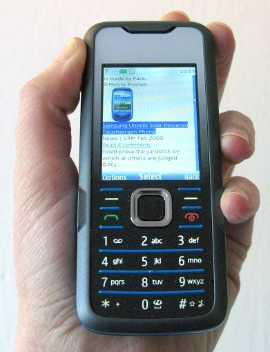 Hand holding a Nokia 7210 Supernova mobile phone.