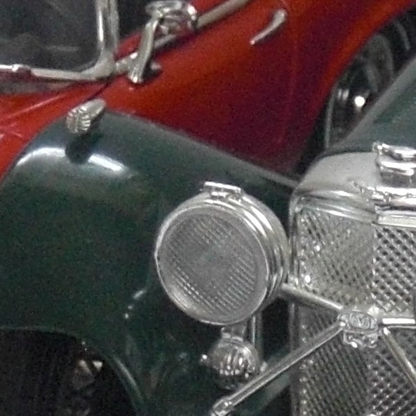 Close-up of a vintage car's headlights and grille.