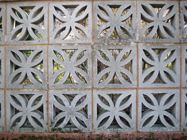 Decorative concrete block wall with leaf patterns.