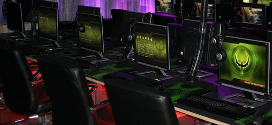 Gaming computers and monitors on desks with green lighting