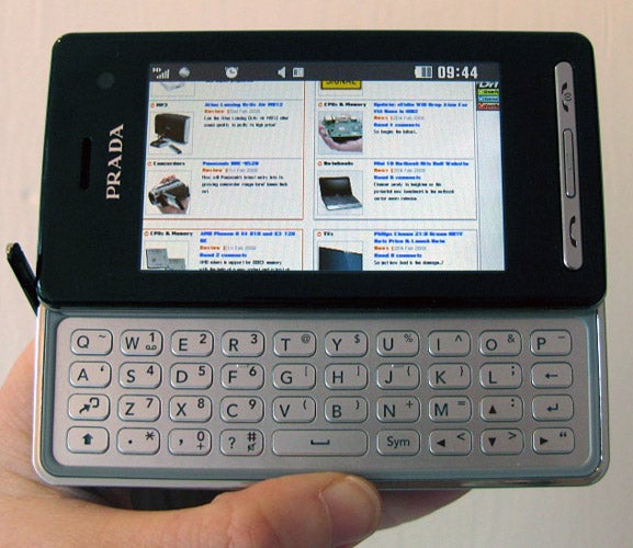 Hand holding LG Prada II KF900 phone with keyboard exposed.