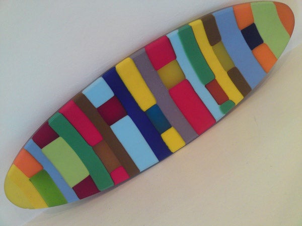 Colorful abstract surfboard-shaped art piece.
