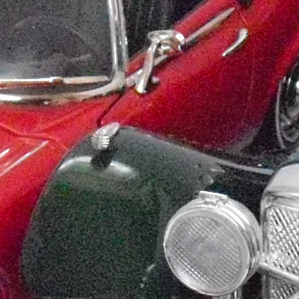 Vintage red car with chrome details and headlights.