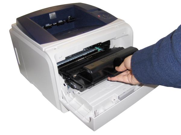 Person loading paper into Xerox Phaser 3435 printer.