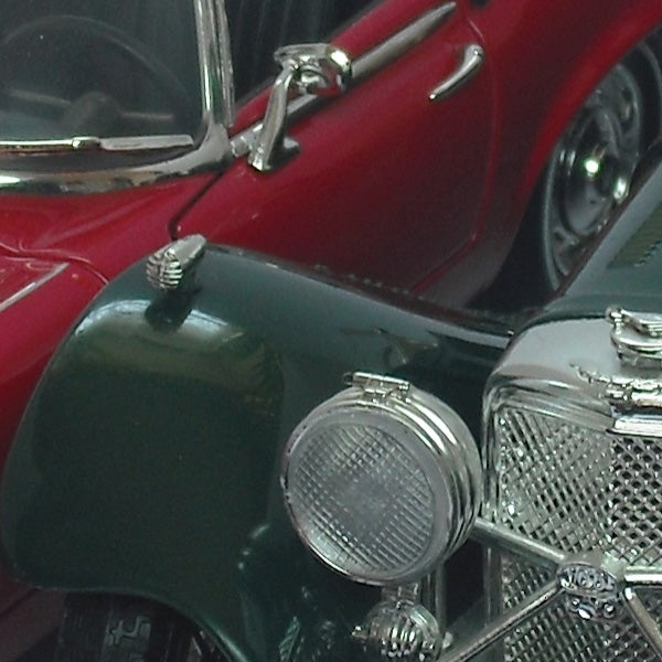 Close-up photo of a vintage red and green car model.