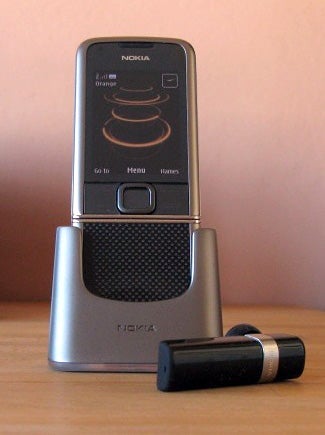 Nokia 8800 Carbon Arte phone with charging stand and headset.