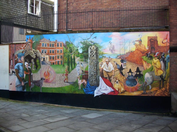 Colorful street mural with historical and fantasy scenes.