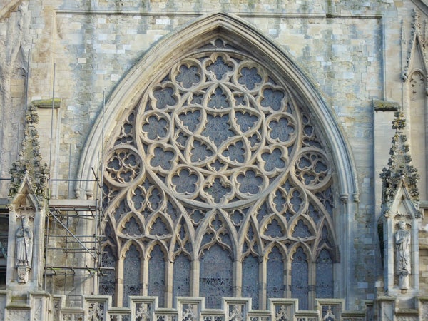 Intricate stone window tracery on a Gothic cathedral facade.