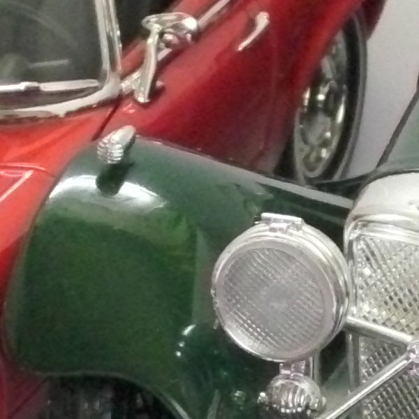 Close-up photo of a vintage red and green car.