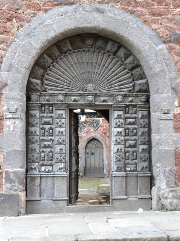 Ancient stone archway with ornate wooden doors captured in detail