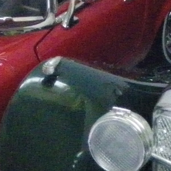 Close-up photo of a classic car's front fender and headlight.