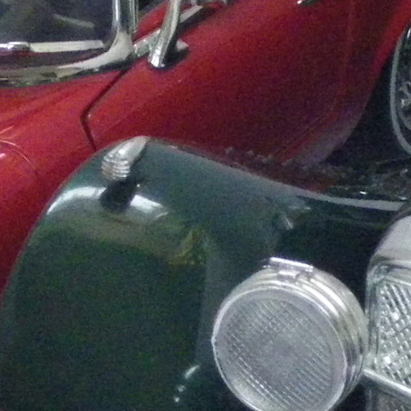 Photograph of a red classic car taken with grainy quality.