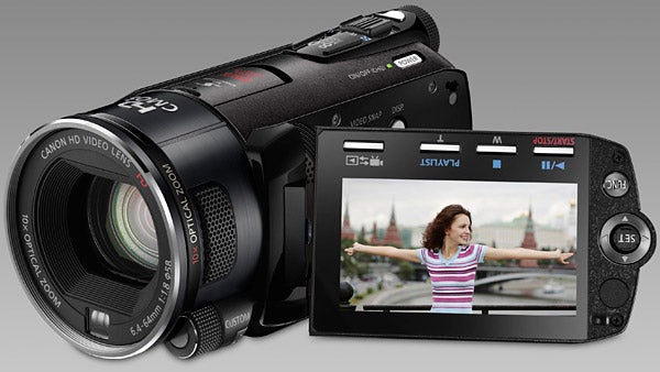 Canon Legria HF S10 camcorder with flip-out screen displaying video.