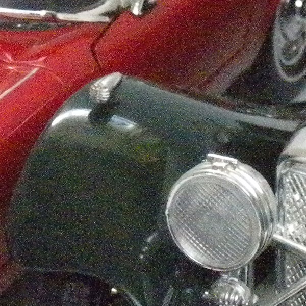 Low-resolution photo of a motorcycle and car