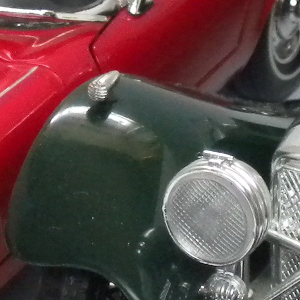 Close-up image of a red and green vintage car.