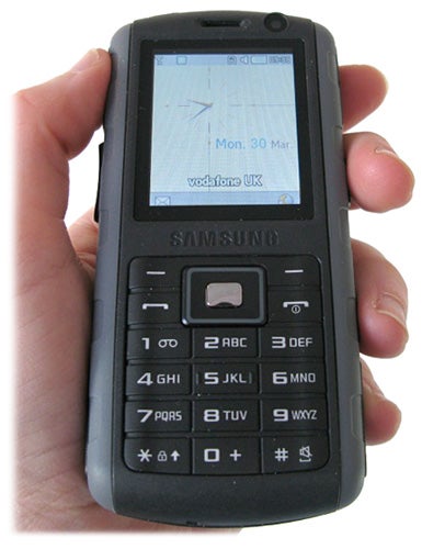 Hand holding Samsung B2700 Bound mobile phone.