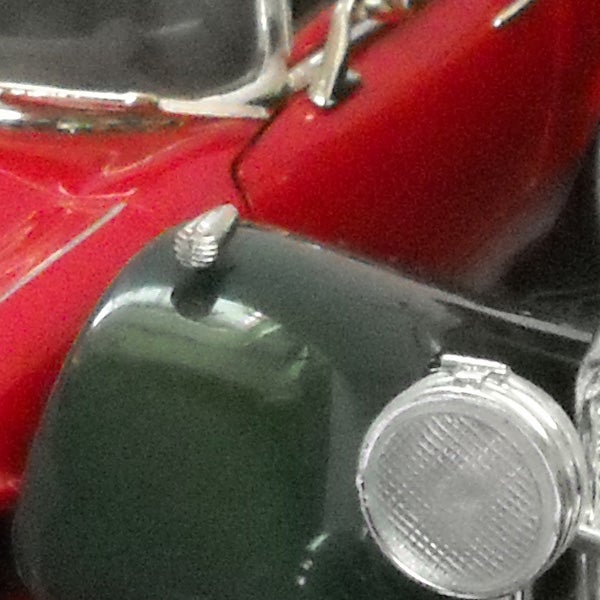 Close-up photo of a classic red and green car.