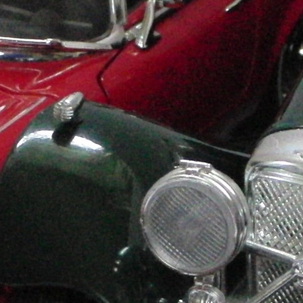 Close-up photo of red and green vintage cars.