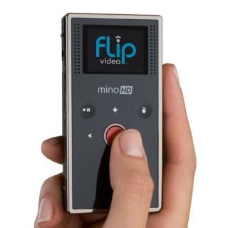 Person holding a Flip Video Mino HD camcorder.