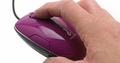 Hand holding a purple Logitech LS1 laser mouse.