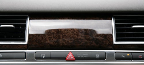 Audi A8 dashboard with hazard light button and wood trim detail.