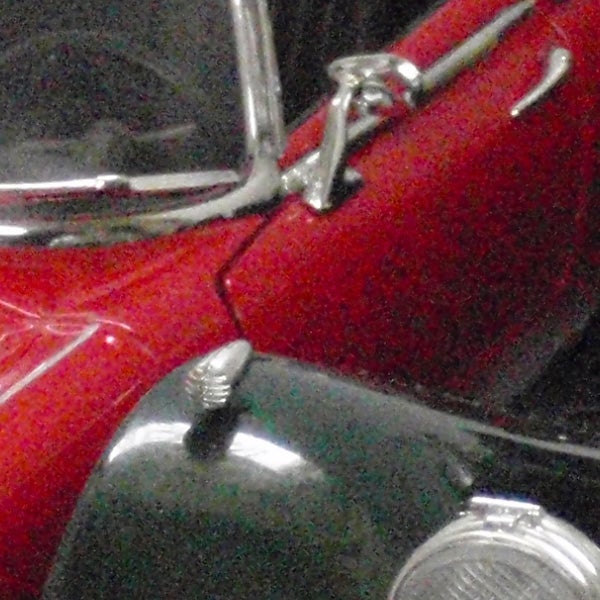 Close-up of a vintage red and black car.