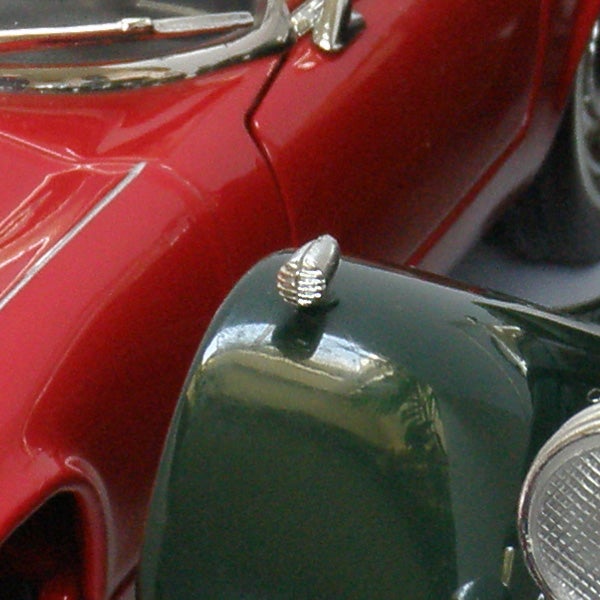 Close-up photo of a red and green vintage car models