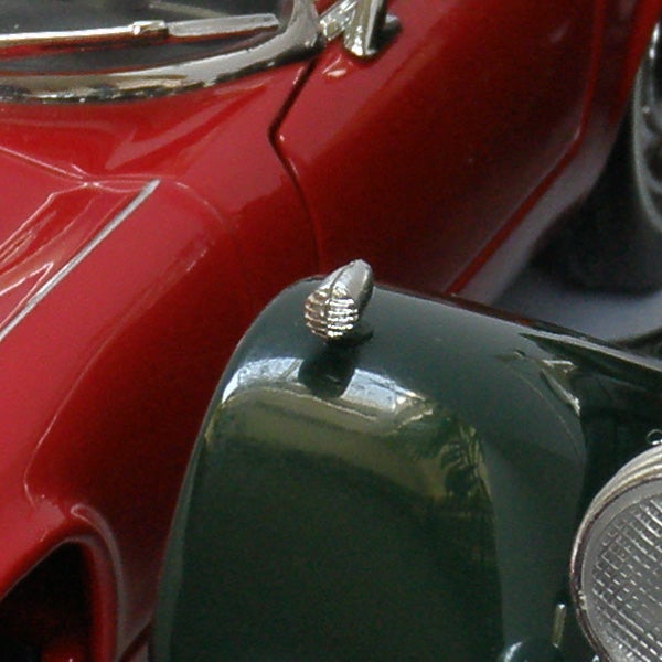 Close-up of a red and green toy car hood and headlights.