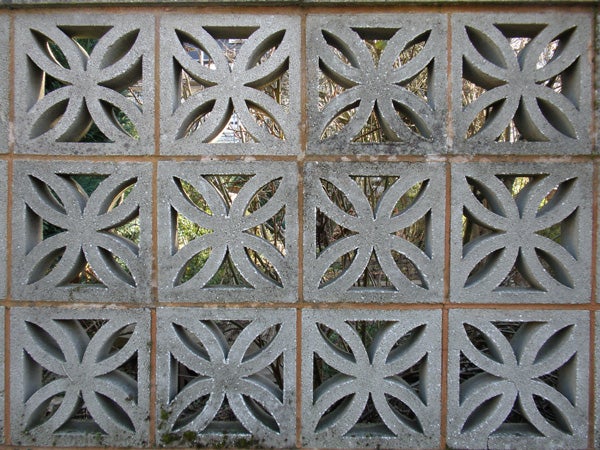 Decorative concrete block wall with floral patterns.