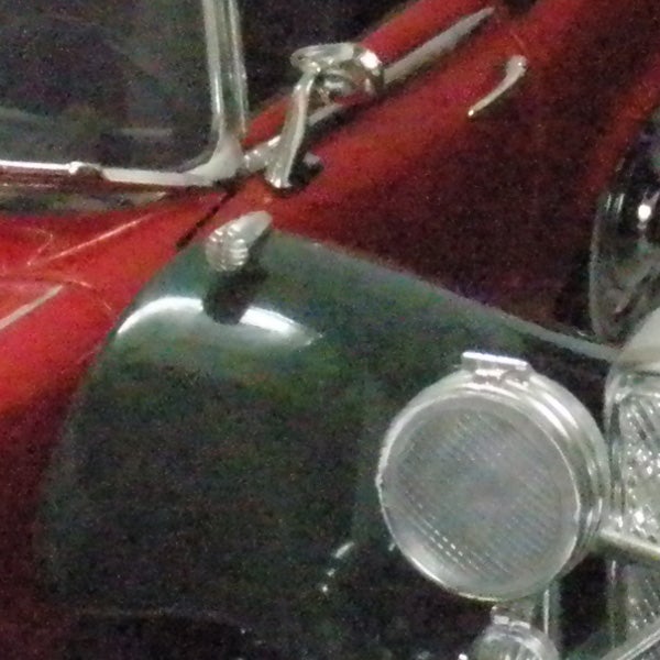 Close-up of vintage car headlight and fender.
