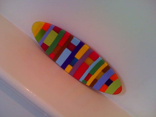 Colorful abstract skateboard deck on white surface.
