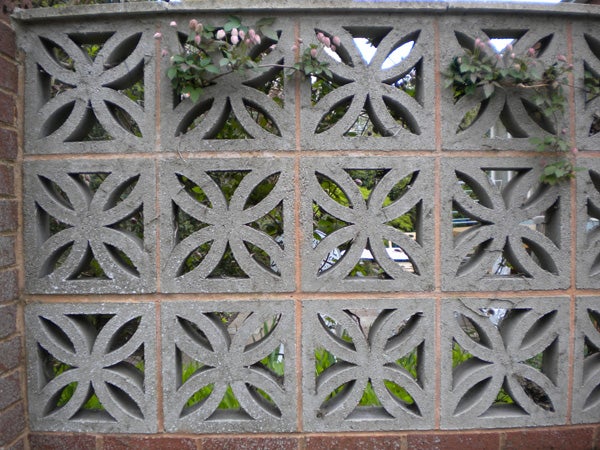 Decorative concrete block wall with visible flowers behind