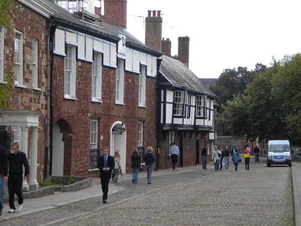 Street scene photograph with people and historic buildings.