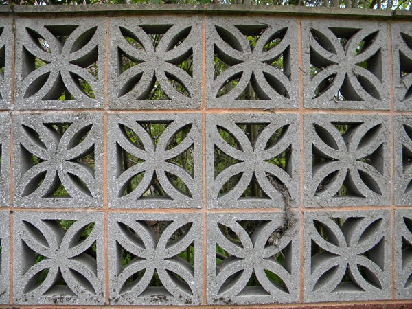 Decorative concrete block wall with a leaf pattern.