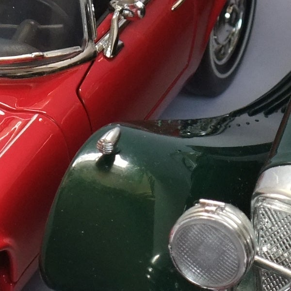 Close-up of a red and green toy car models.