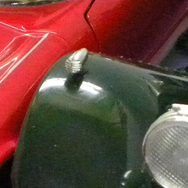 Close-up of vintage car hood and headlight.