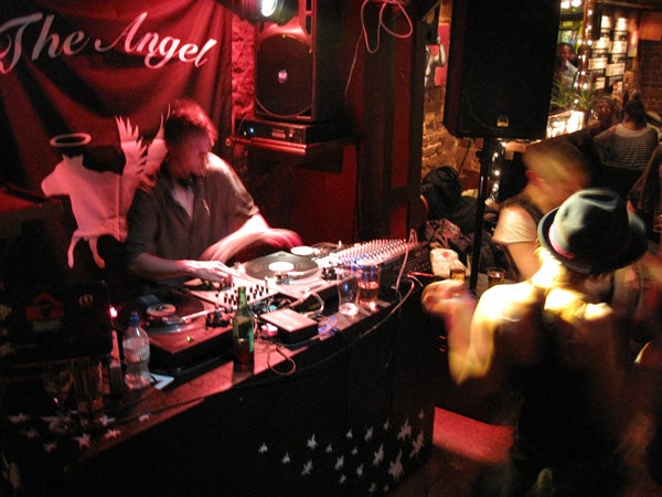 Low-light photo of a DJ booth at a club with motion blur