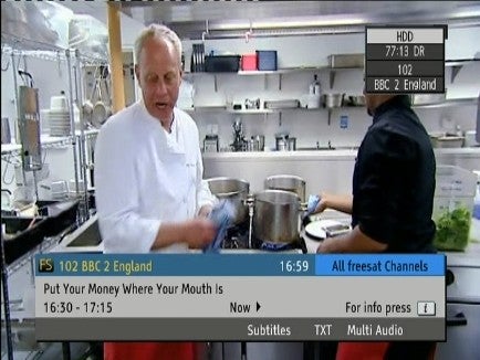 TV screen showing Panasonic recorder interface with a cooking show in background.