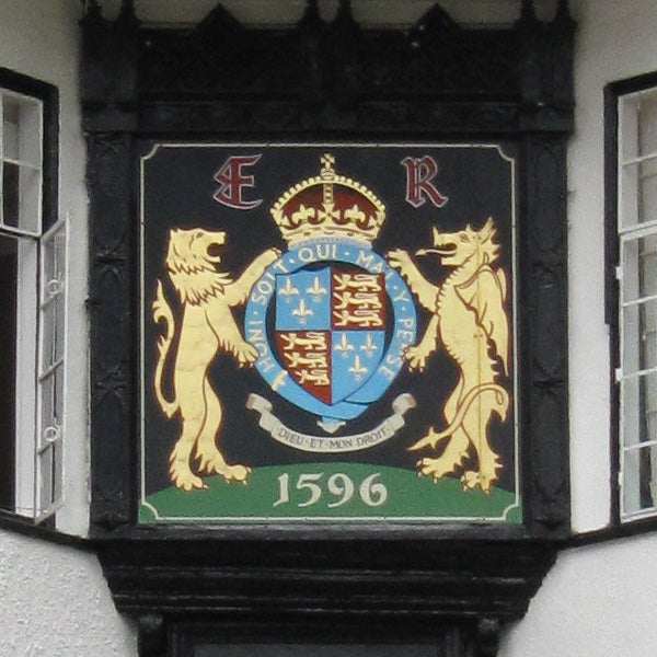 Coat of arms with lions and a crown, displayed on a building.
