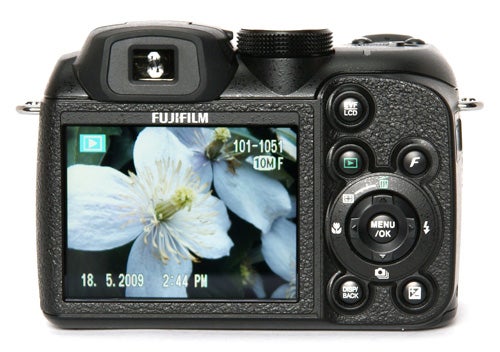 Fujifilm FinePix S1500 camera displaying a flower photo on screen.