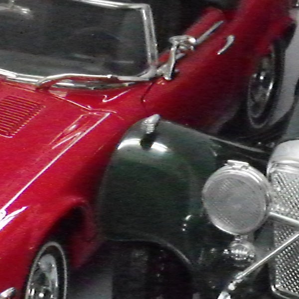 Close-up photo of a red vintage car toy.Close-up of a red vintage car toy model