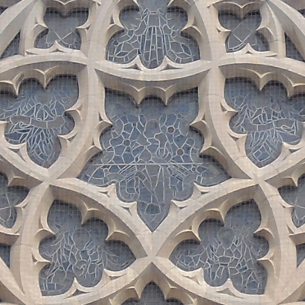 Close-up of intricate stone lattice work on a building facade.