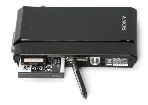 Sony Cyber-shot DSC-T900 camera with battery compartment open.