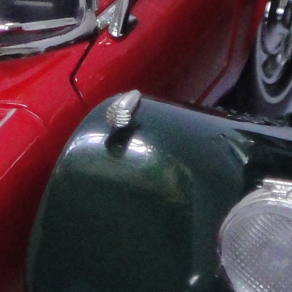 Close-up of vintage green and red cars showing detail.