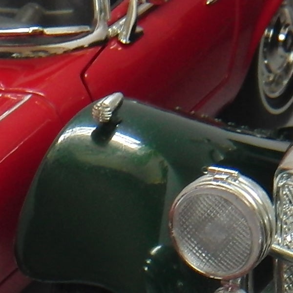 Close-up of a green and red toy car's front section.