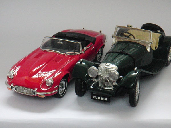 Two model vintage cars on a white background