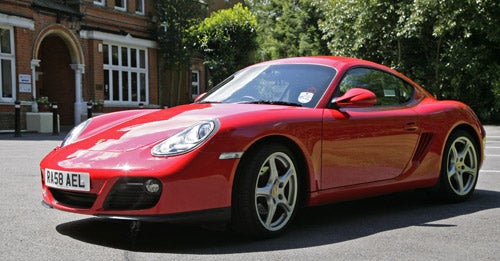 Red Porsche Cayman 2.9 PDK parked outside a building